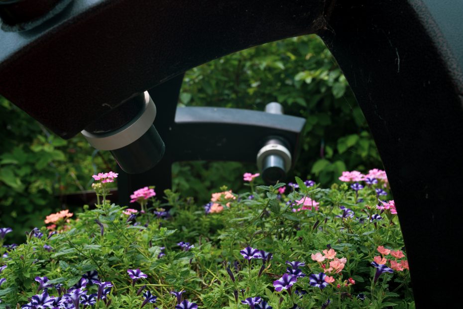 kaleidoscope sculpture with eyepieces aimed at bowl of annual flowers which are blooming